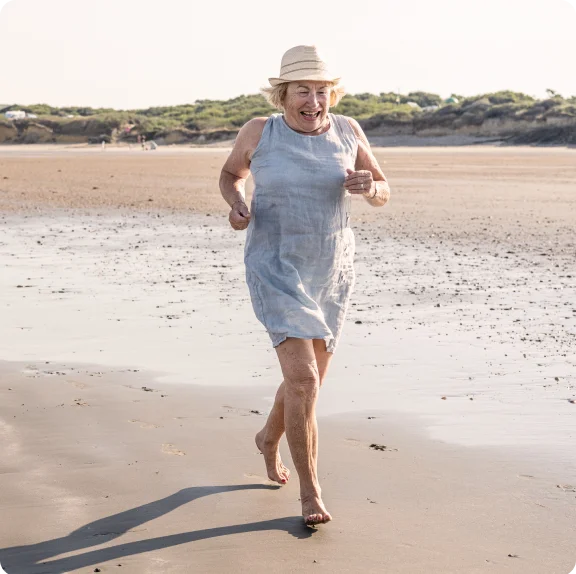 Osoba biegnąca po plaży.